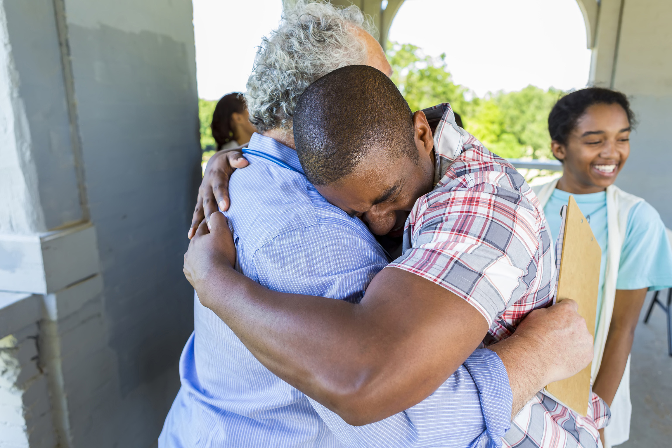 older man hugging younger man