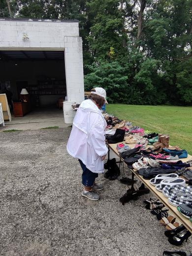 person in white coat and hat looking at shoes on a table