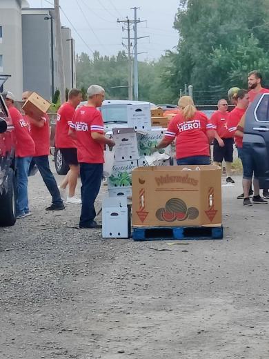 people in red shirts distributing food boxes