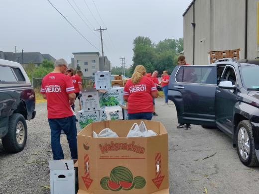 people in red shirts distributing food boxes