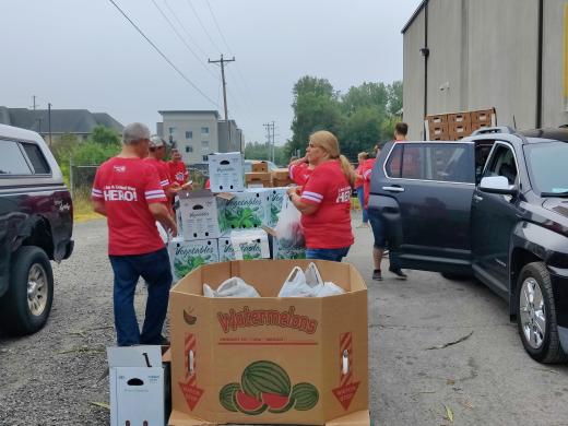 people in red shirts distributing food boxes