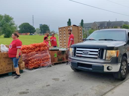 people in red shirts distributing food boxes