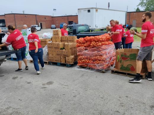 people in red shirts distributing food boxes