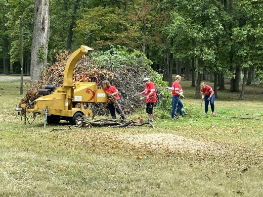 women running a wood chipper