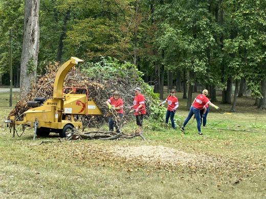 women running a wood chipper