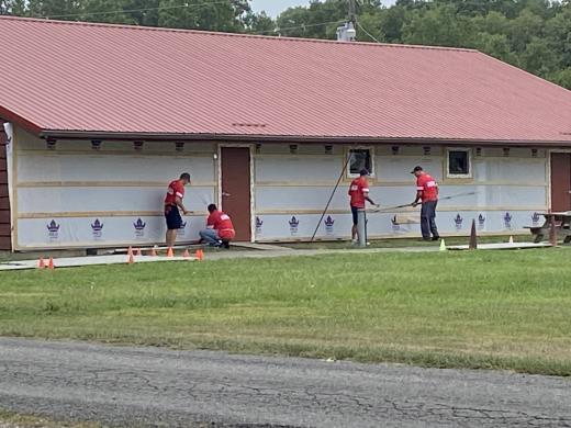 four men working on siding a building