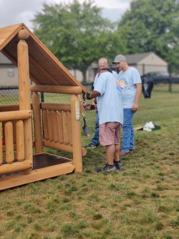 Man checking to see if a log cabin playset rood if level